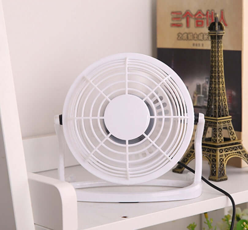 New Mini Portable Ultra Quiet USB Fan on white desk with Eiffel Tower model in background