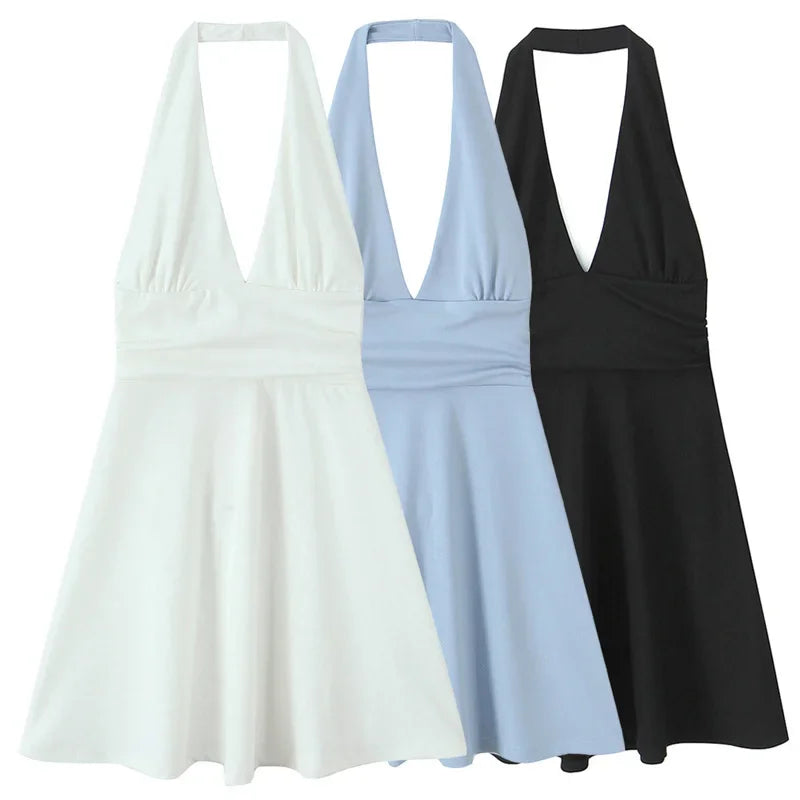 Three halter mini dresses in white, light blue, and black, featuring a backless design and above-knee length.