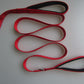 Red double handle pull leash with reflective strip and metal buckle for pet walking.