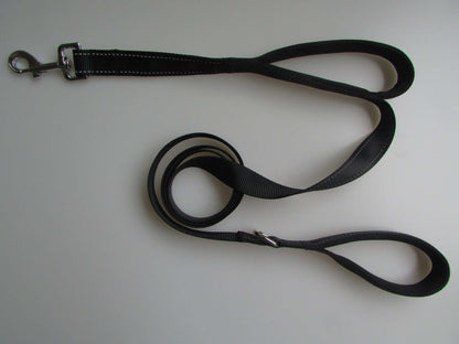 Black double handle pet leash made of durable nylon, featuring a metal buckle and reflective stitching for safety.